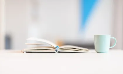 Notitieboekje van Bliksem Schrijfbureau ligt open op tafel, met kop koffie ernaast