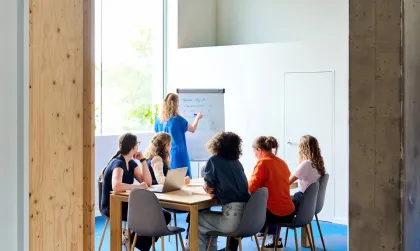 Bliksem Schrijfbureau zit aan tafel te brainstormen, terwijl copywriter Marlies de ideeën opschrijft op een wit schrijfbord