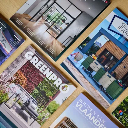 Bovenaanzicht van tafel vol vakbladen van Louwers Mediagroep, waar de copywriters van Bliksem Schrijfbureau aan meeschreven