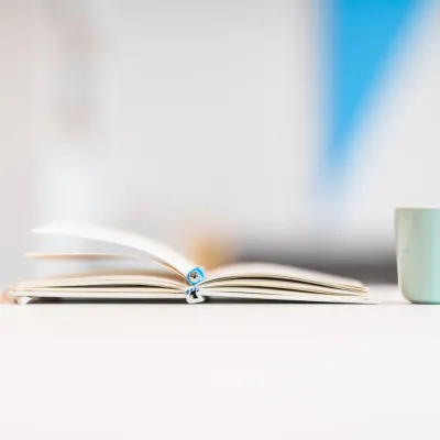 Notitieboekje van Bliksem Schrijfbureau ligt open op tafel, met kop koffie ernaast