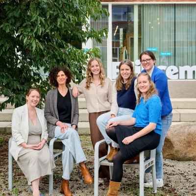 Copywriters van Bliksem Schrijfbureau zitten neer op de stoelen aan het Pioniersplein in Zwevegem
