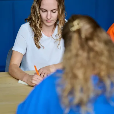 Copywriter Majorie neemt notities tijdens vergadering met Bliksem Schrijfbureau