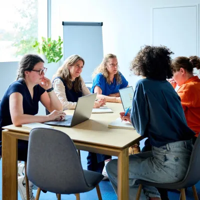 De copywriters van Bliksem Schrijfbureau vergaderen aan de tafel