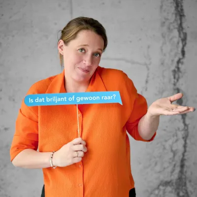 Copywriter Anastasia Verleysen met blauwe tekstballon in de hand waarop staat "is dat briljant of gewoon raar?"