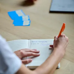 Copywriter van Bliksem Schrijfbureau neemt notities op pen en papier