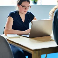 Copywriter Stephanie neemt notities op haar laptop